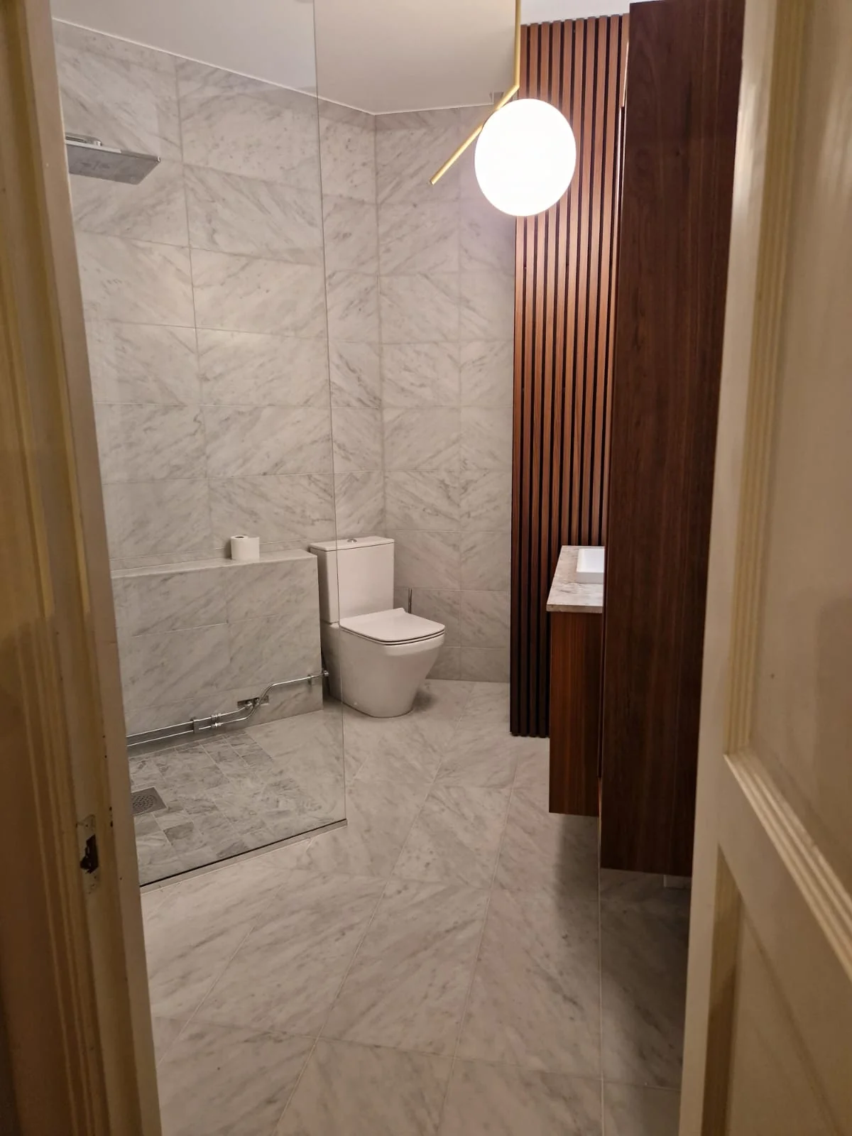 Renoverat badrum med ekkommod och rund spegel