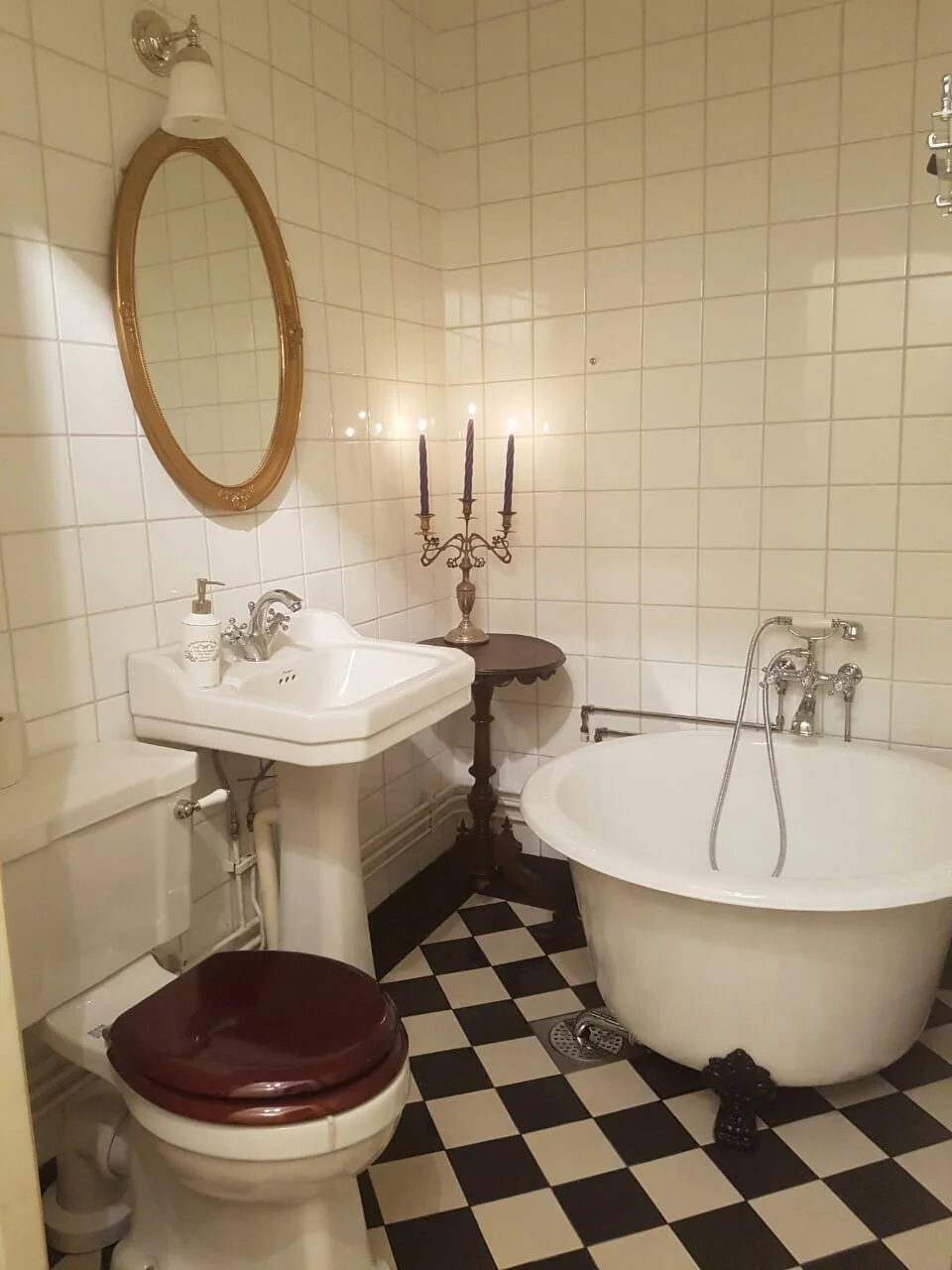 Renoverat badrum med ekkommod och rund spegel